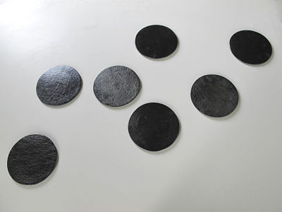 Sandra Moneny, Lunas negras (7), 2019 Vidrio negro fun dido con plata en superficie, 16 diámetro.